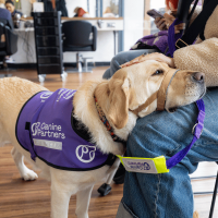 Assistance dog Shelley assisting their partner Meikle at the hairdresser.